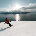 skiers descending snowy mountain