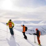 skiers on snowy mountain peak